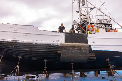 Young Quinault tribal fisherman apply bottom side paint to their dry-docked crab boat in preparation for the coming crab fishing season later in the fall, at Boat Haven Marina in Port Townsend, Washington, on July 24, 2023